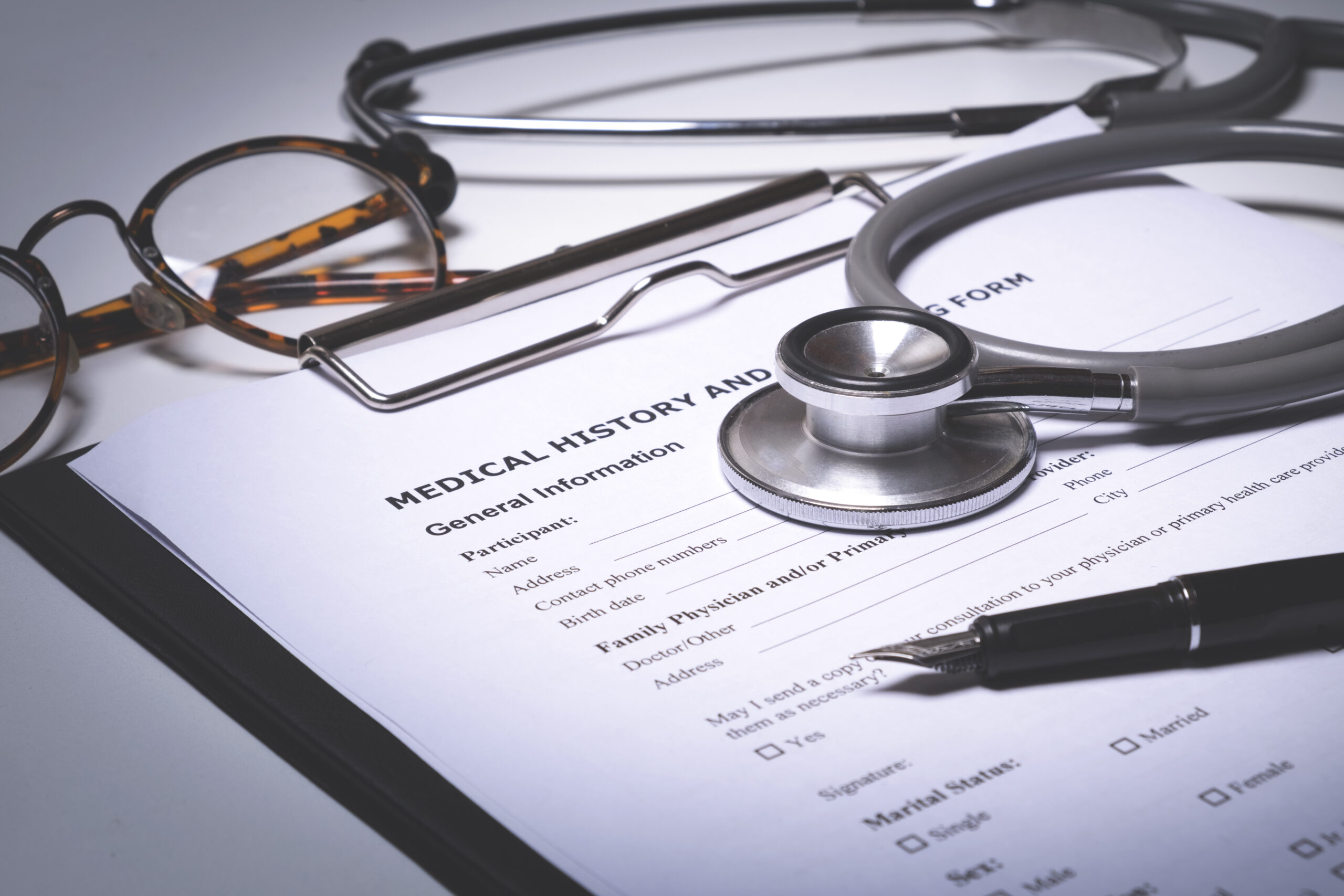 doctor desktop with stethoscope, clipboard with medical records form.